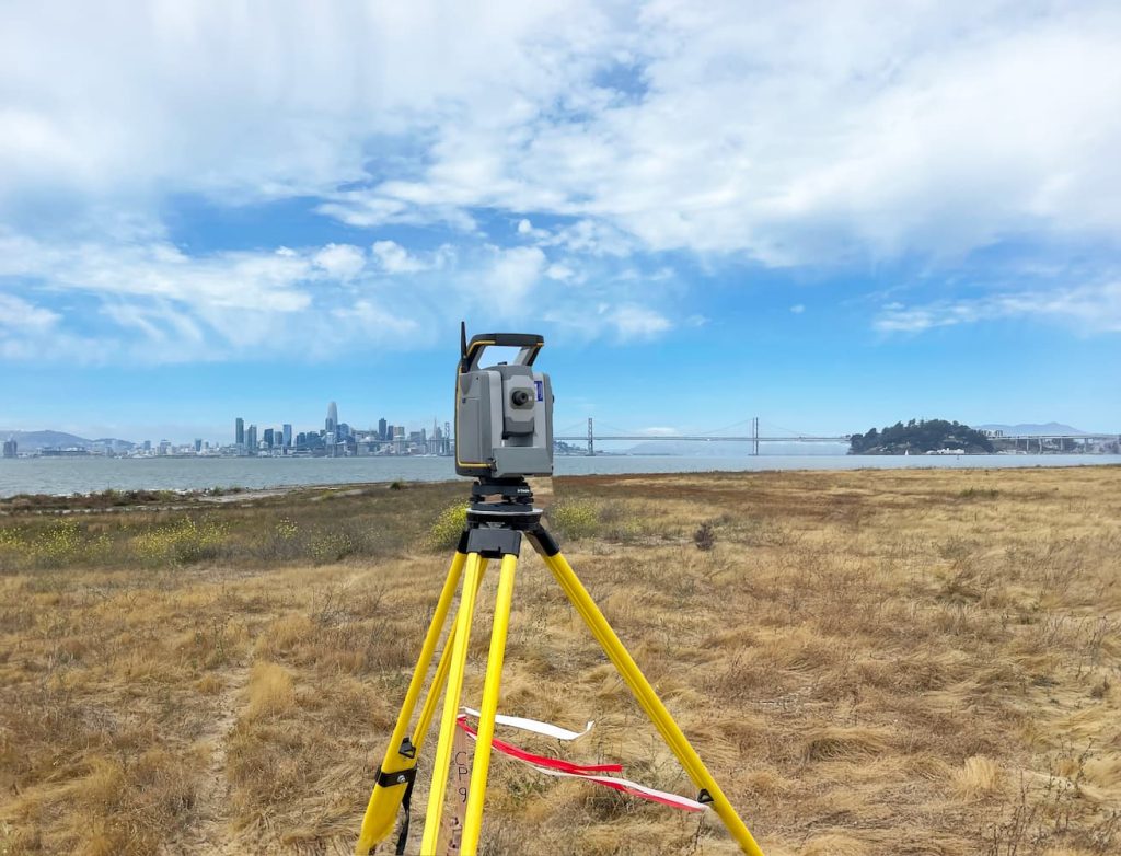 land surveying tool in a field showcasing the engineering services of the survey and mapping group at Sanbell