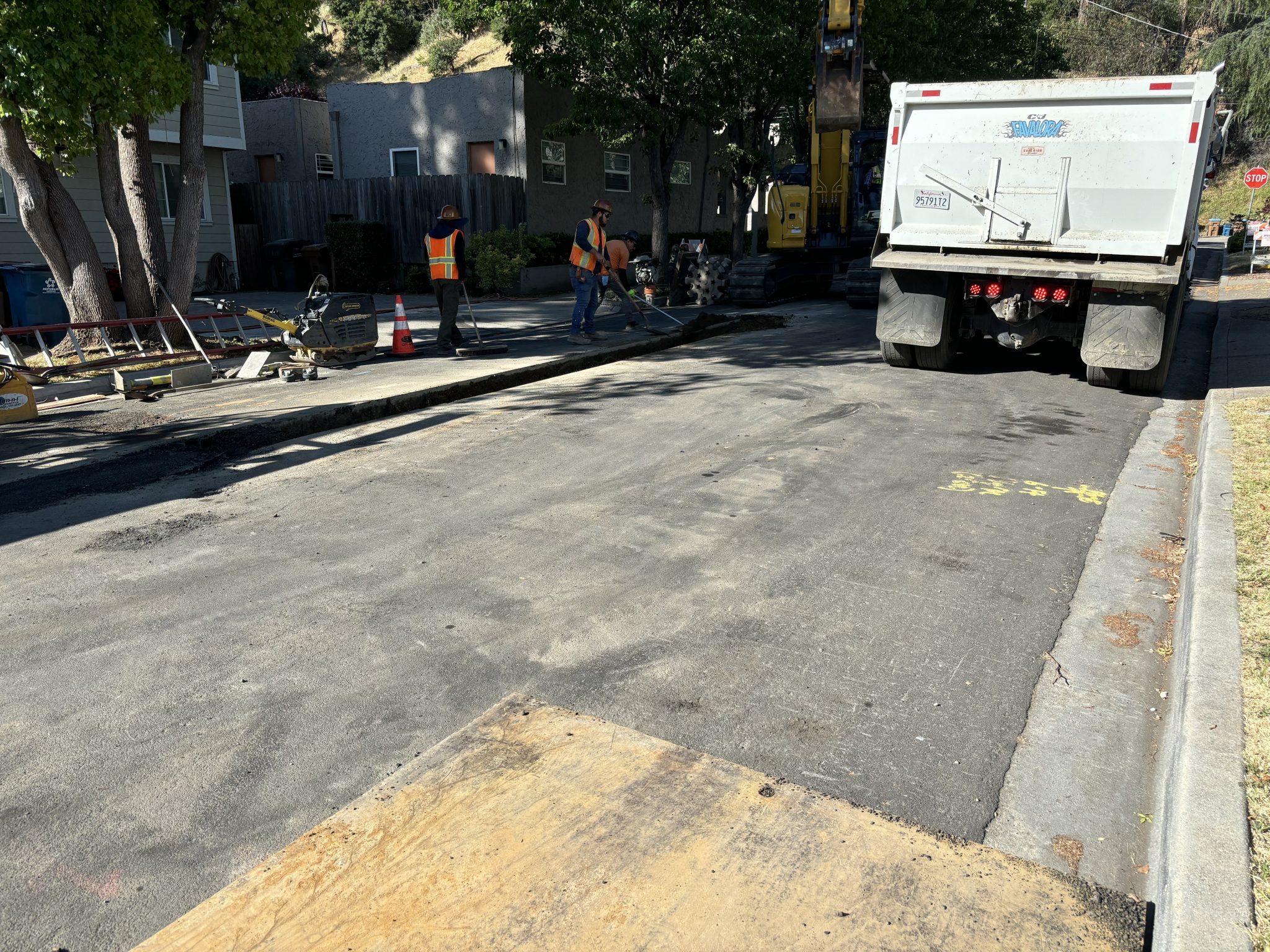Construction crew pouring new asphalt after installing new City of Martinez water main.