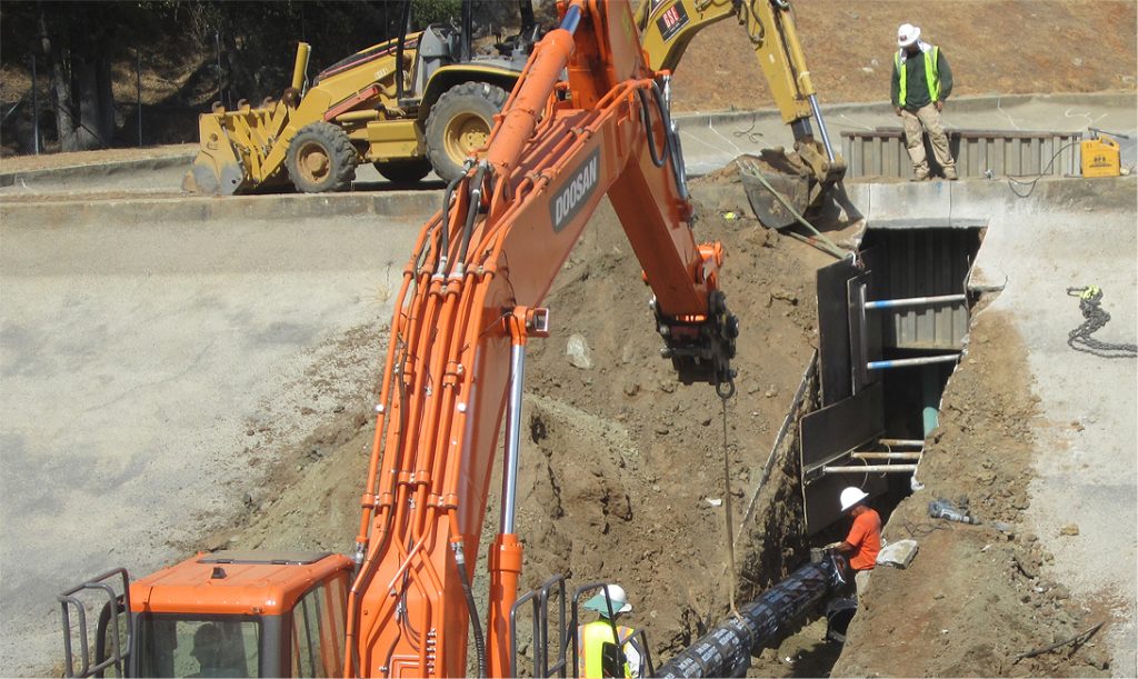 Construction workers digging trenches during the Tuolumne wastewater treatment plant upgrades under Sanbell design.